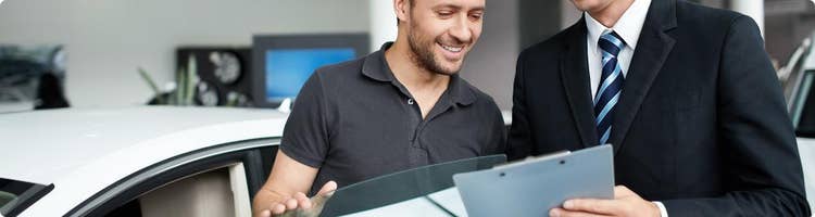 car salesman shows customer used vehicle
