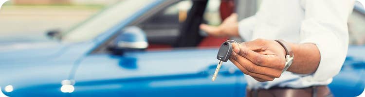 man holds key to new car
