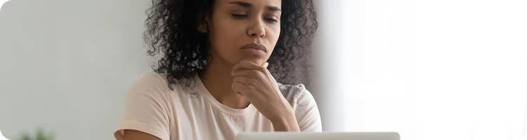 worried woman looks at computer screen