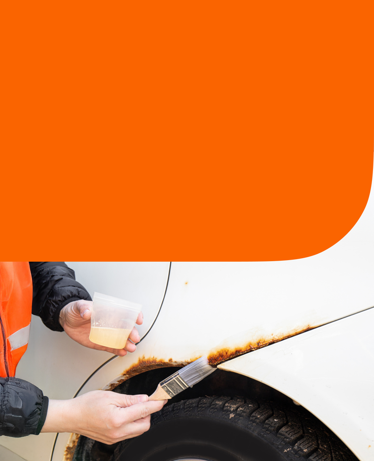 A man fixing rust on his car