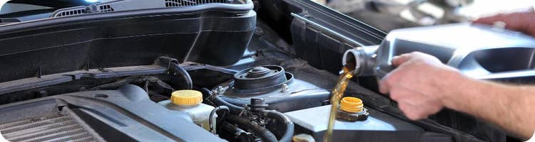 close-up pouring oil into vehicle