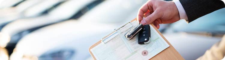 man holds car registration and car keys
